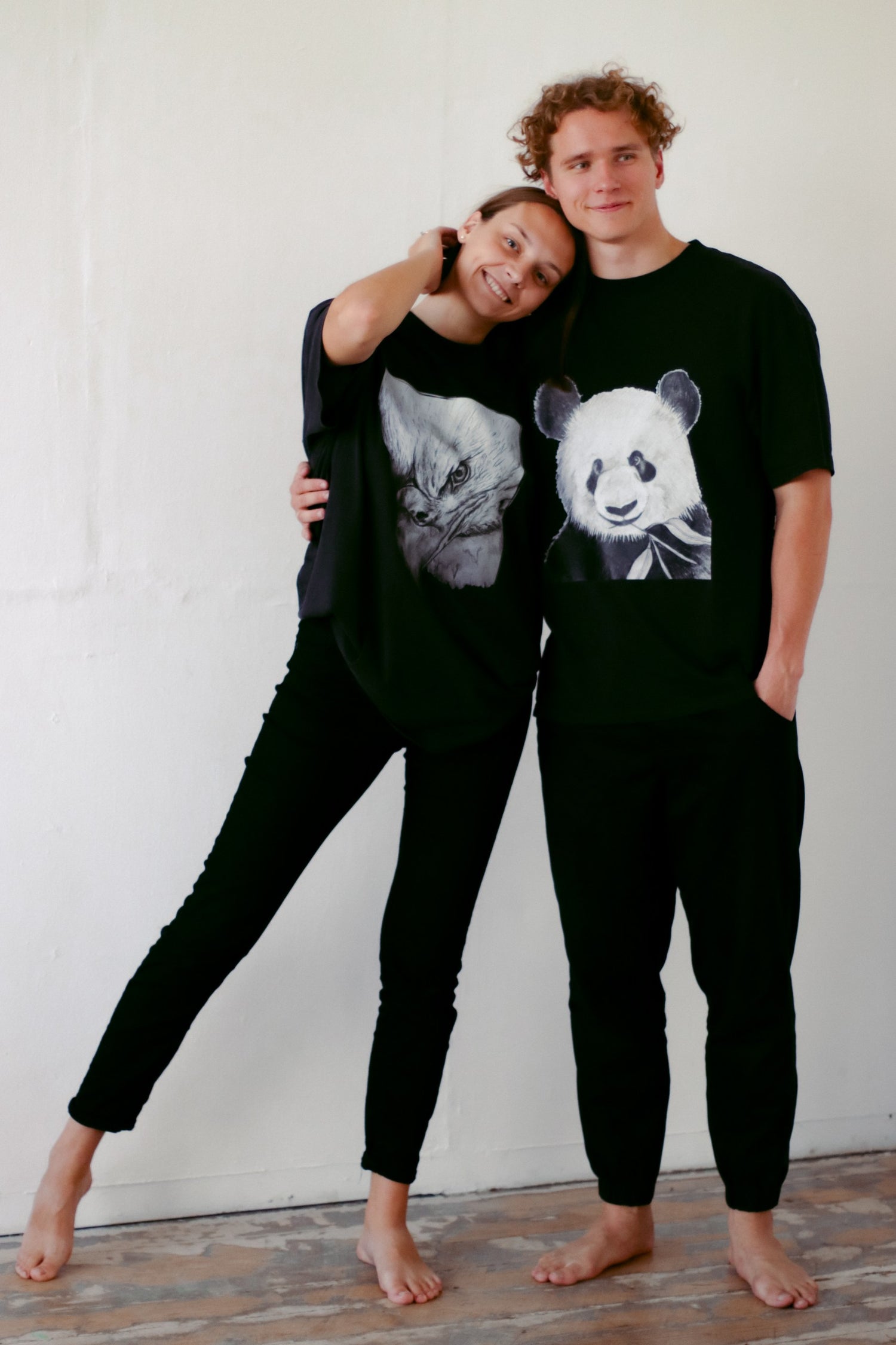 A married couple posing for the picture with exclusive niibercotton shirts with eagle and panda on the front of the shirts, they seem matched and in love